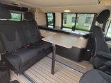 two seats in the back of a van with a table in the back