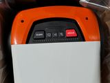 une machine orange et blanche posée à l'intérieur d'une boîte, elle-même posée sur un carton