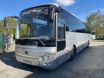 un bus argenté garé sur le bord de la route