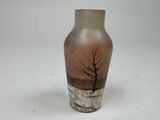 a brown vase with a tree on it sitting on a table