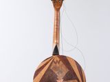 an image of a guitar hanging from a string on a white wall