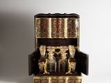 an ornately decorated wooden box with gold and red decorations