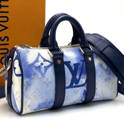 a blue and white louis vu bag next to a brown box