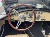 steering wheel and dashboard of a vintage car in a parking lot