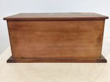 wooden box with lid on a white table with a white wall in the background