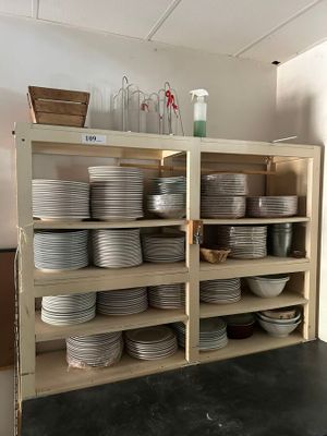 de nombreuses assiettes et bols empilés sur les étagères de la cuisine