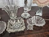 a lot of glass items on a table with a lamp