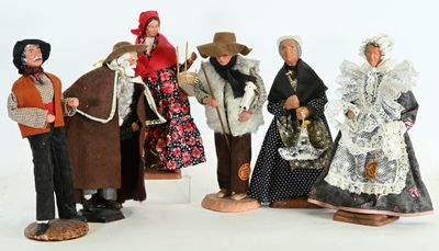 five figurines of people dressed in historical clothing