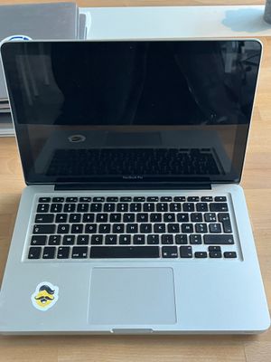 a laptop computer sitting on top of a wooden table