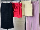 three different colored skirts hanging on a clothes rack in a room