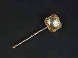 a close up of a silver spoon on a black surface