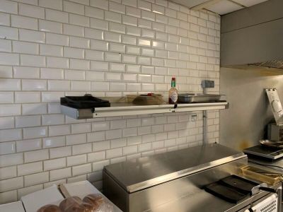 une photo d'une cuisine avec une cuisinière et des étagères