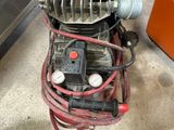 a small air compressor sitting on the floor in the garage