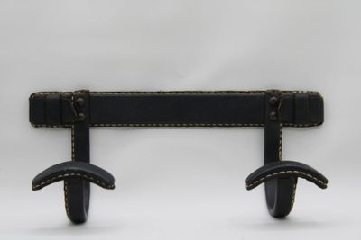 pair of black leather wall hooks on a white background