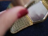 a person holding a gold watch with a chain around it