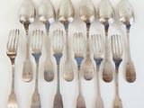 a lot of silver spoons and forks on the table