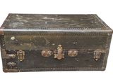 une vieille valise posée sur une surface blanche