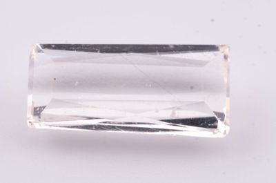 Gros plan sur un cristal de quartz transparent posé sur une surface blanche