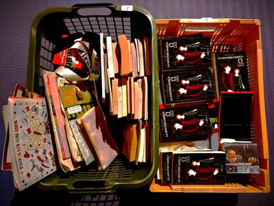 un panier vert rempli d'objets divers posé sur une table