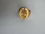 une image représentant une bague en or ornée d'un blason et d'une couronne