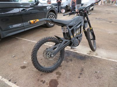 une moto tout-terrain garée sur un parking à côté d'une voiture