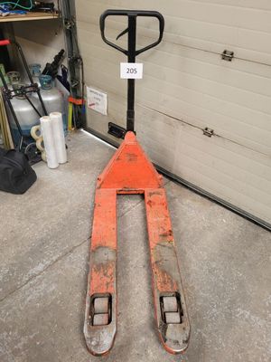 a forklift sitting in a garage next to a garage door