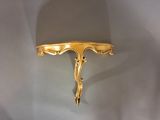 a gold plate on a wall with a spoon on top of it