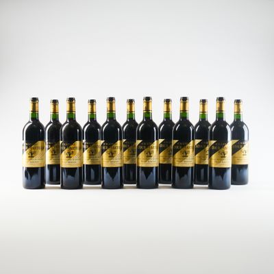 six bouteilles de vin sont alignées sur une surface blanche