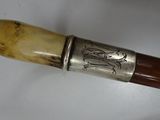 a close up of a wooden stick with a metal handle
