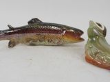 two figurines of a fish and a shoe on a white surface