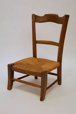 a wooden chair with a wicker seat on a white background