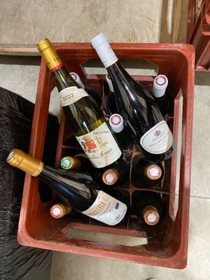 de nombreuses bouteilles de vin dans une boîte rouge posée par terre