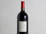 a bottle of red wine sitting on a wooden table