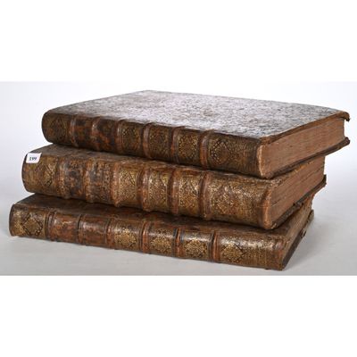 three old books stacked on top of each other on a table