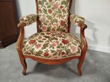 a chair with a floral upholstered back and arms