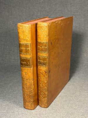 two old books sitting on top of each other on a table