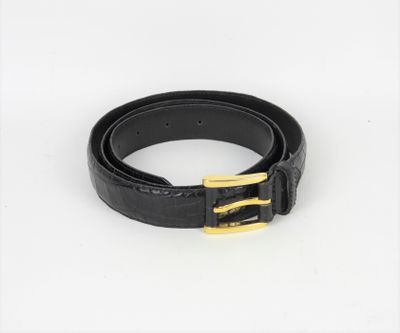une ceinture noire ornée d'une boucle dorée sur fond blanc