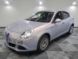 La voiture blanche est garée sur le sol à damier de la pièce.