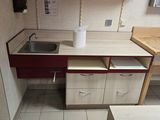 une petite cuisine équipée d'un évier et de placards