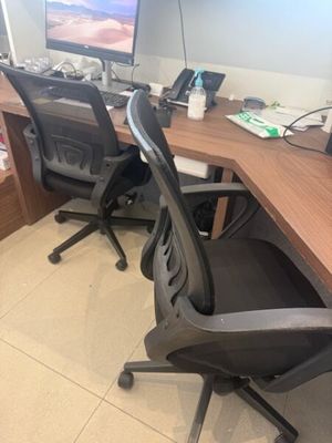 un bureau d'ordinateur avec deux chaises et un écran posé dessus