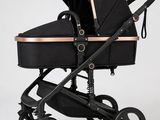 une poussette noire et dorée avec un siège noir sur fond blanc