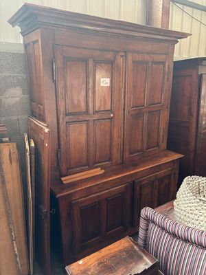 un canapé et un fauteuil dans une pièce où se trouve une armoire en bois