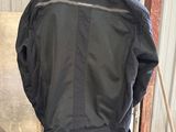 a black jacket sitting on top of a chair in a room
