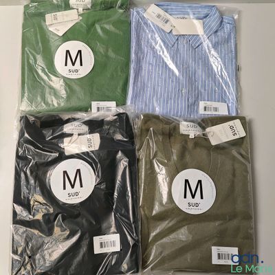 Trois chemises pour homme sont emballées dans des sacs en plastique posés sur une table