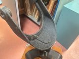 a metal clamp on a wooden stand in a room