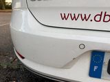 the back end of a white car with a red and blue sticker on it