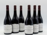 six bouteilles de vin sont alignées sur une surface blanche