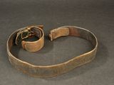 an old leather belt with a metal buckle on a black surface