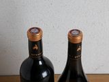 two bottles of wine that are sitting on a table