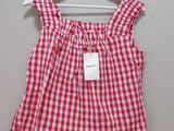 a red and white checkered top hanging on a hanger
